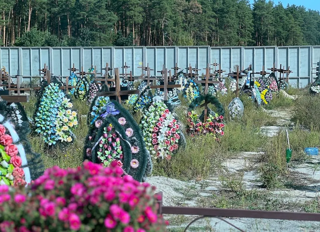 Wooden crosses and flower wreaths at the Bucha cemetery, Ukraine