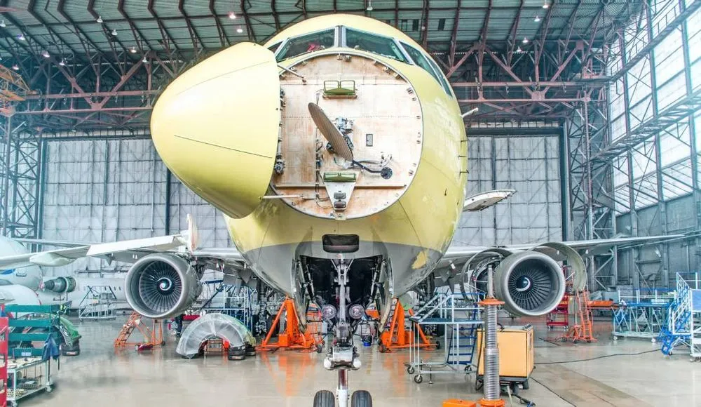 Airplane in a hangar getting maintenance done.