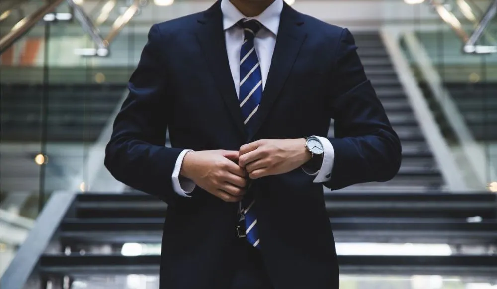 An executive buttoning his suit