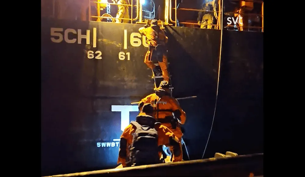 Swedish Coast Guard personnel board the ship Vezhen